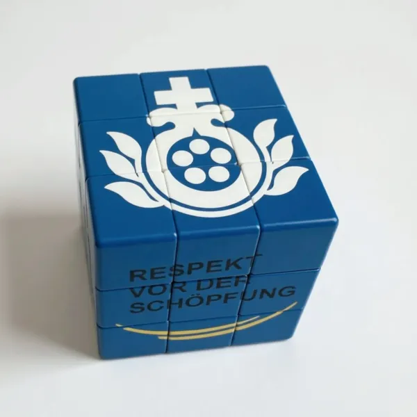 Ein blauer Rubik Cube mit weißem BHB Logo